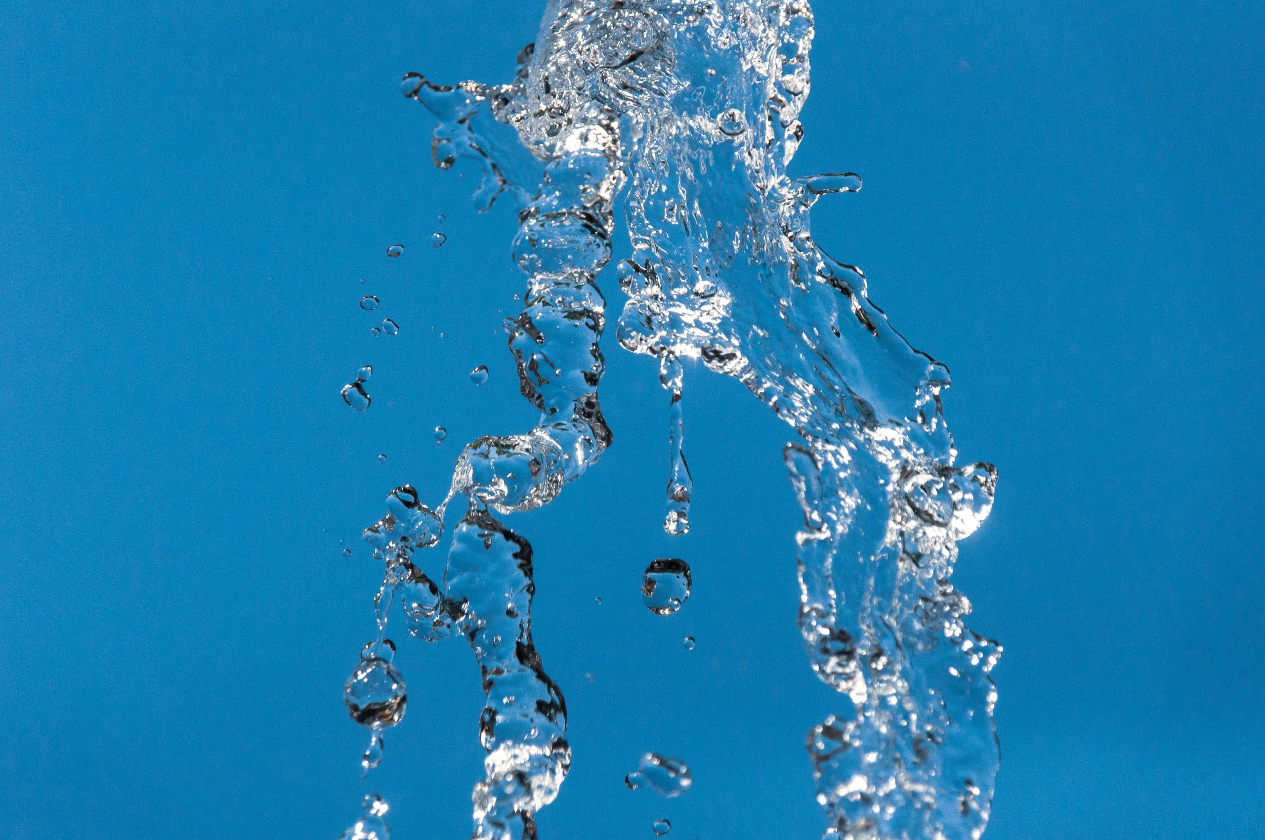 Éclaboussure eau claire fond bleu vif
