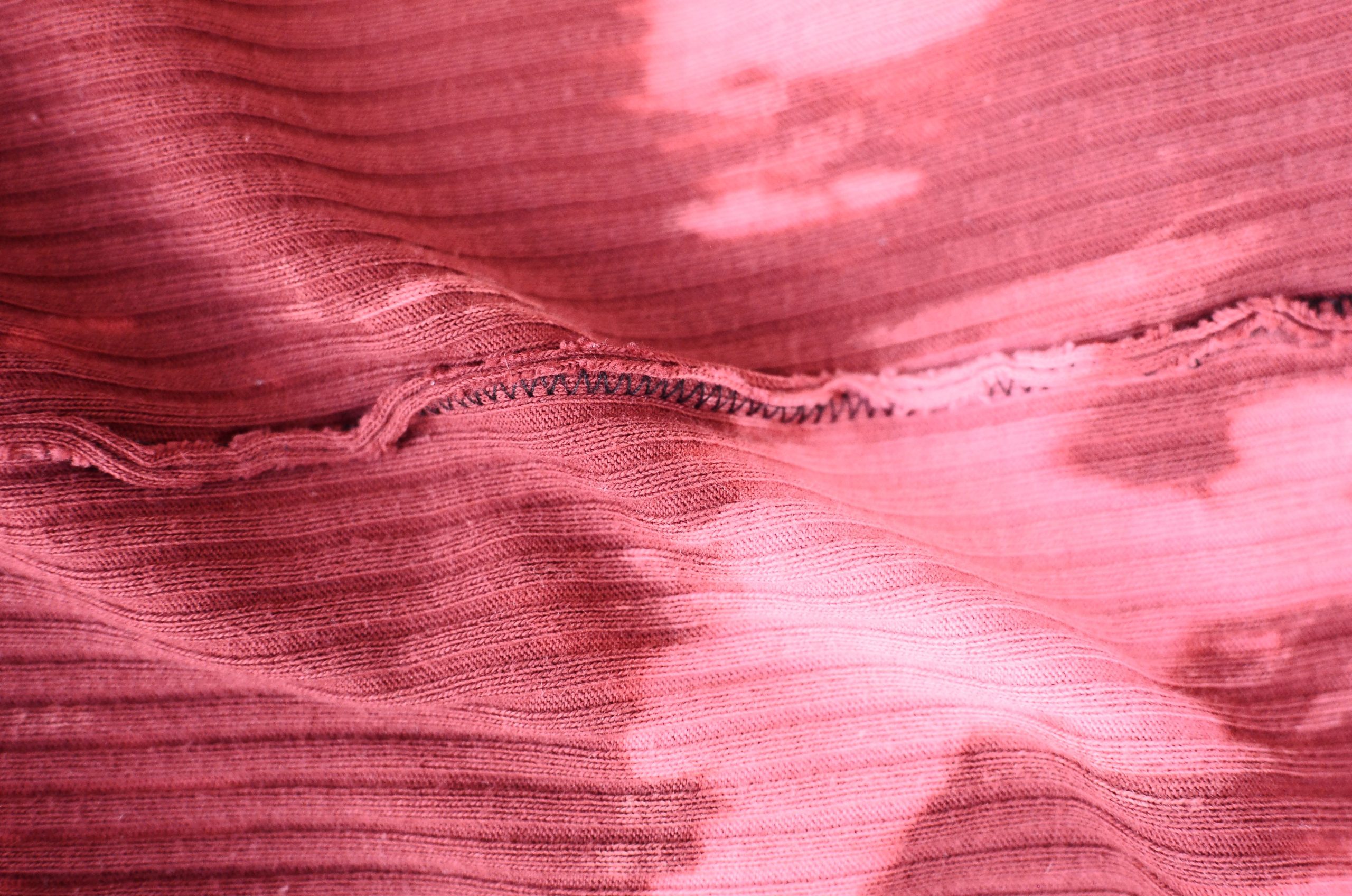 Tissu rose froissé avec taches visibles