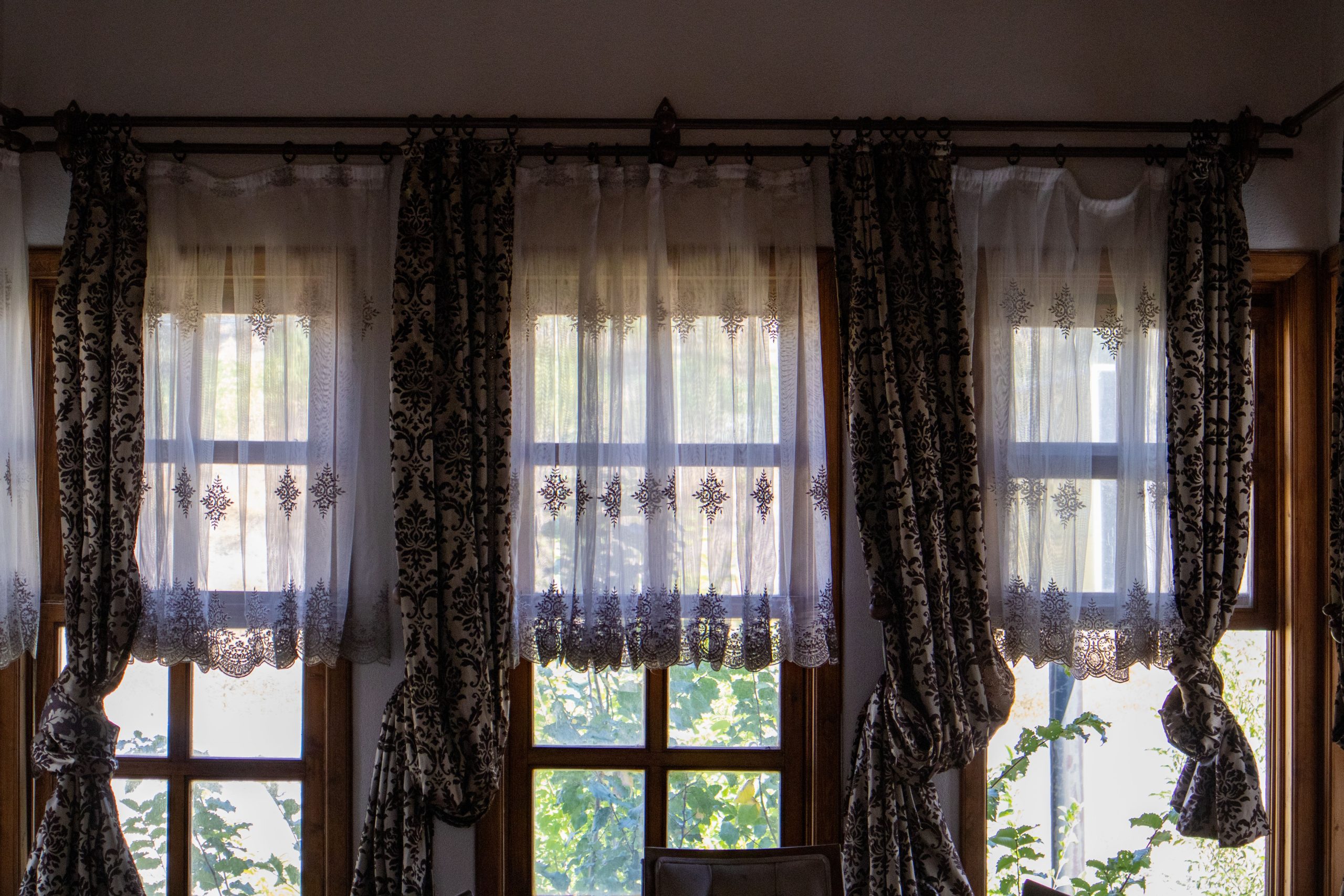 Rideaux élégants traditionnels devant vue jardin.