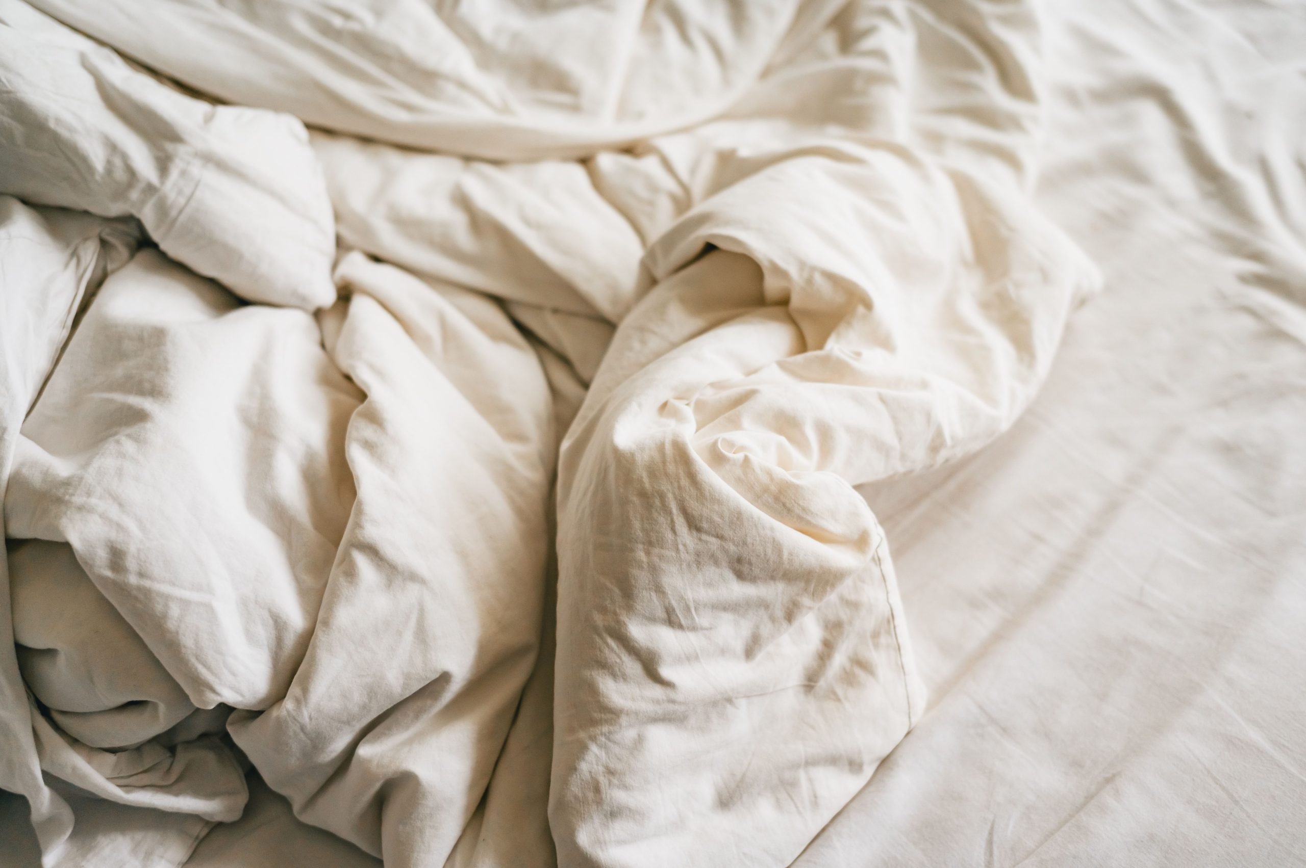 Draps blancs froissés et confortables en gros plan