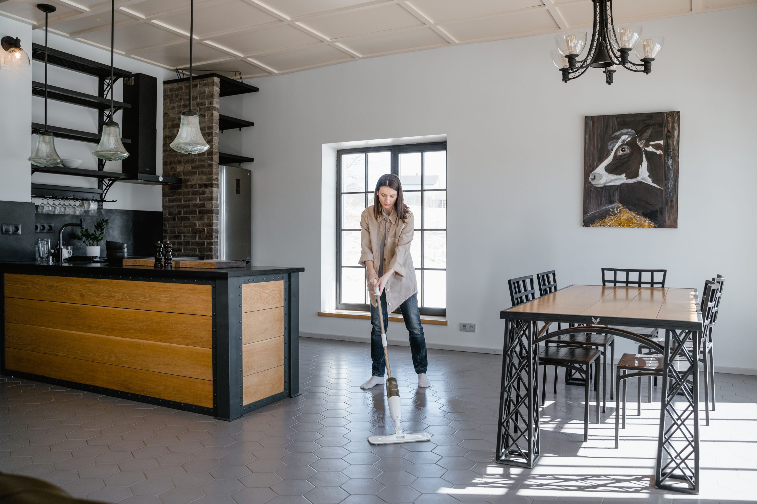 Femme passant la mop dans une cuisine lumineuse