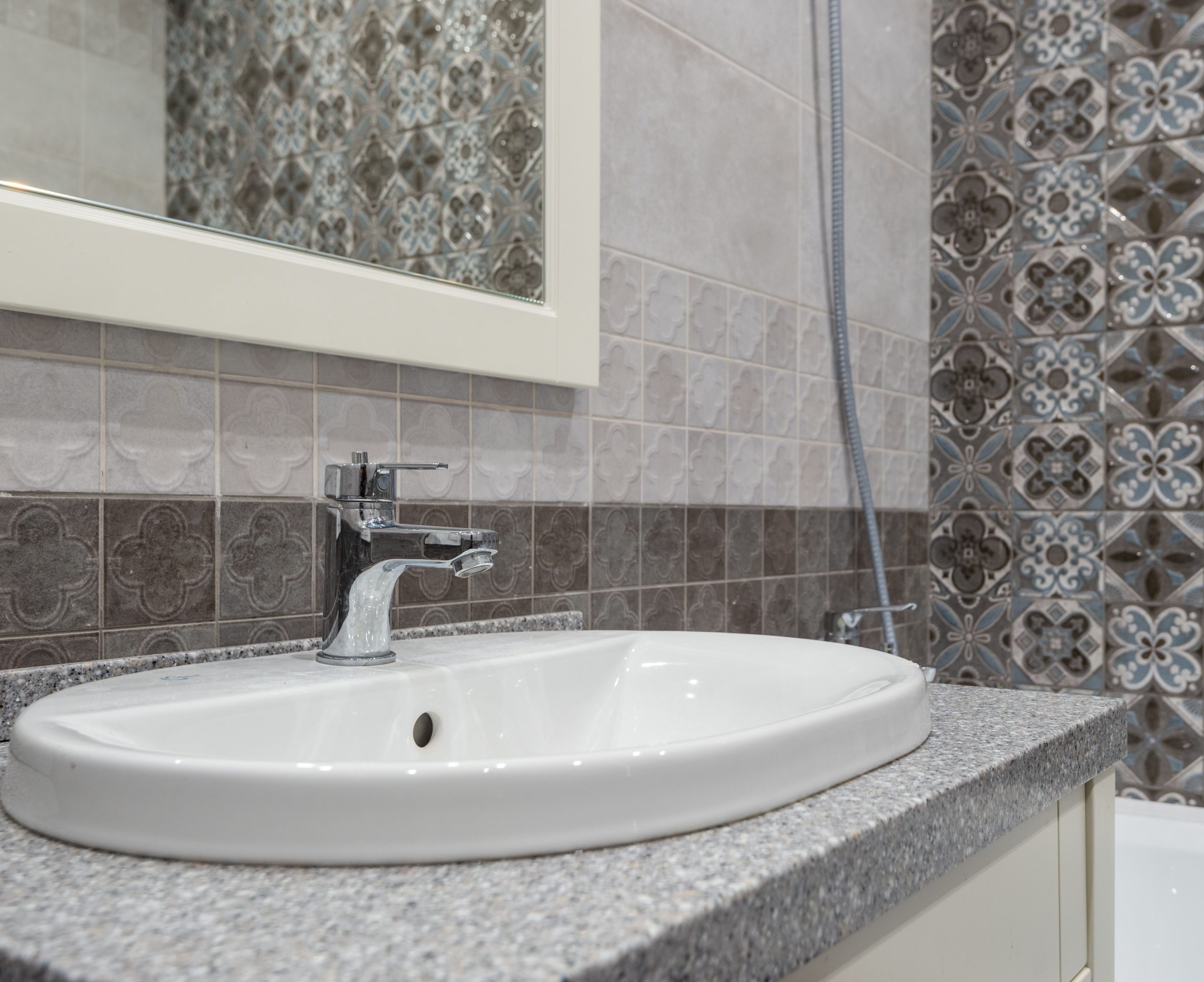 Crédence carrelée motifs au-dessus lavabo blanc
