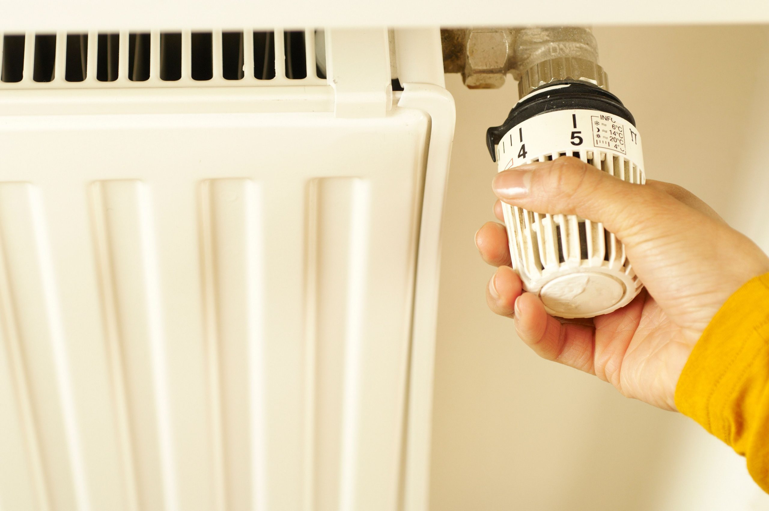 Main réglant un thermostat de radiateur